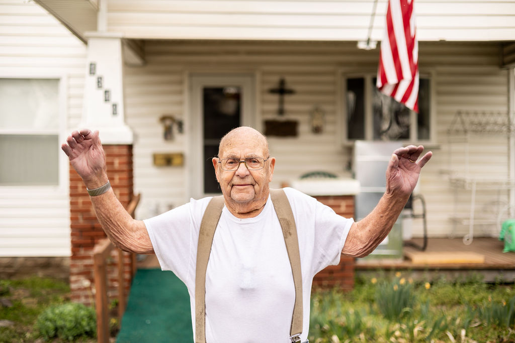 Bob, a Jenks veteran, in front of his home with the American flag